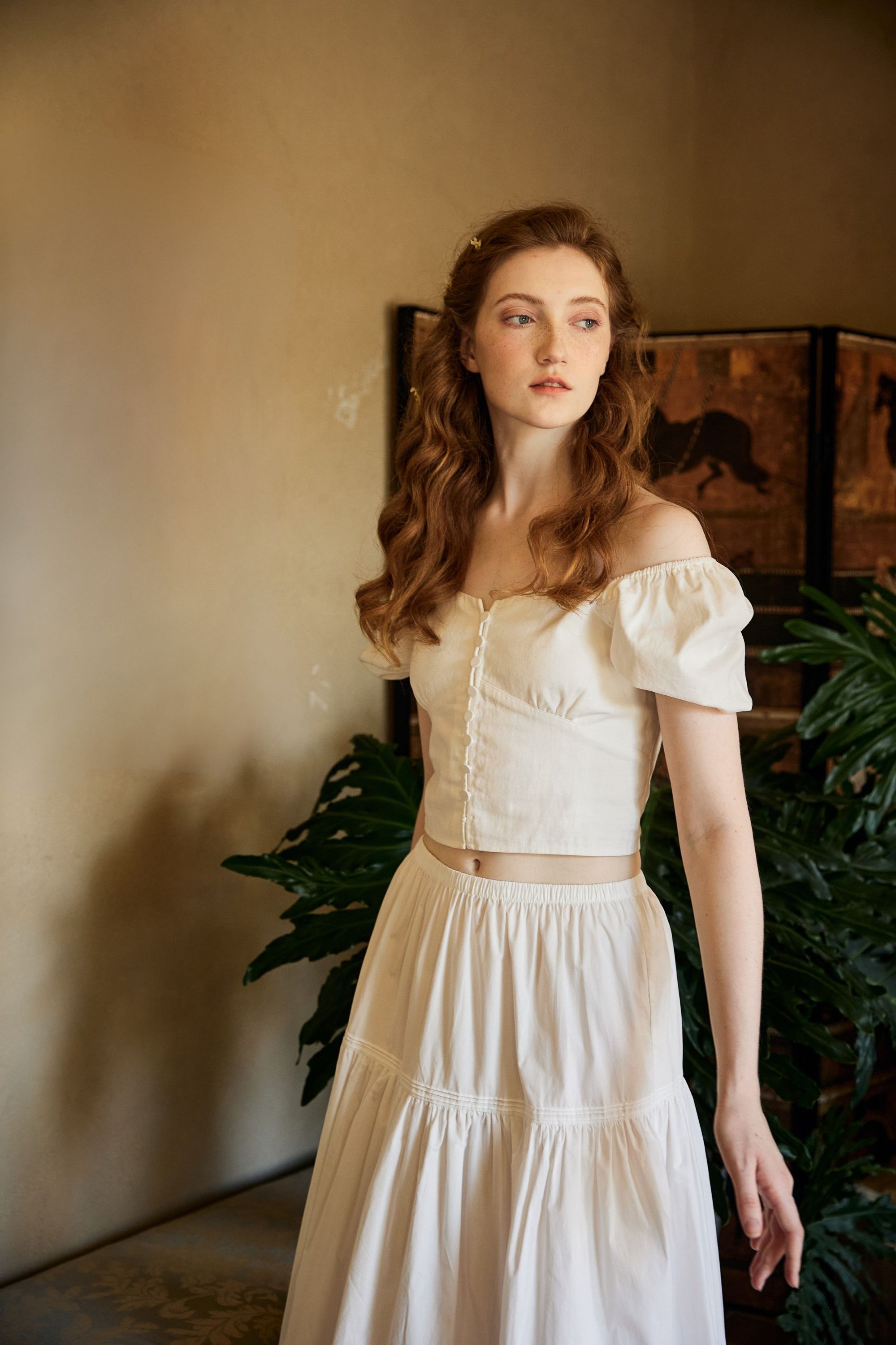 Woman wearing a Neo-classical inspired lightweight white cotton maxi skirt with a comfortable flexible elastic waistband, styled with a vintage top.