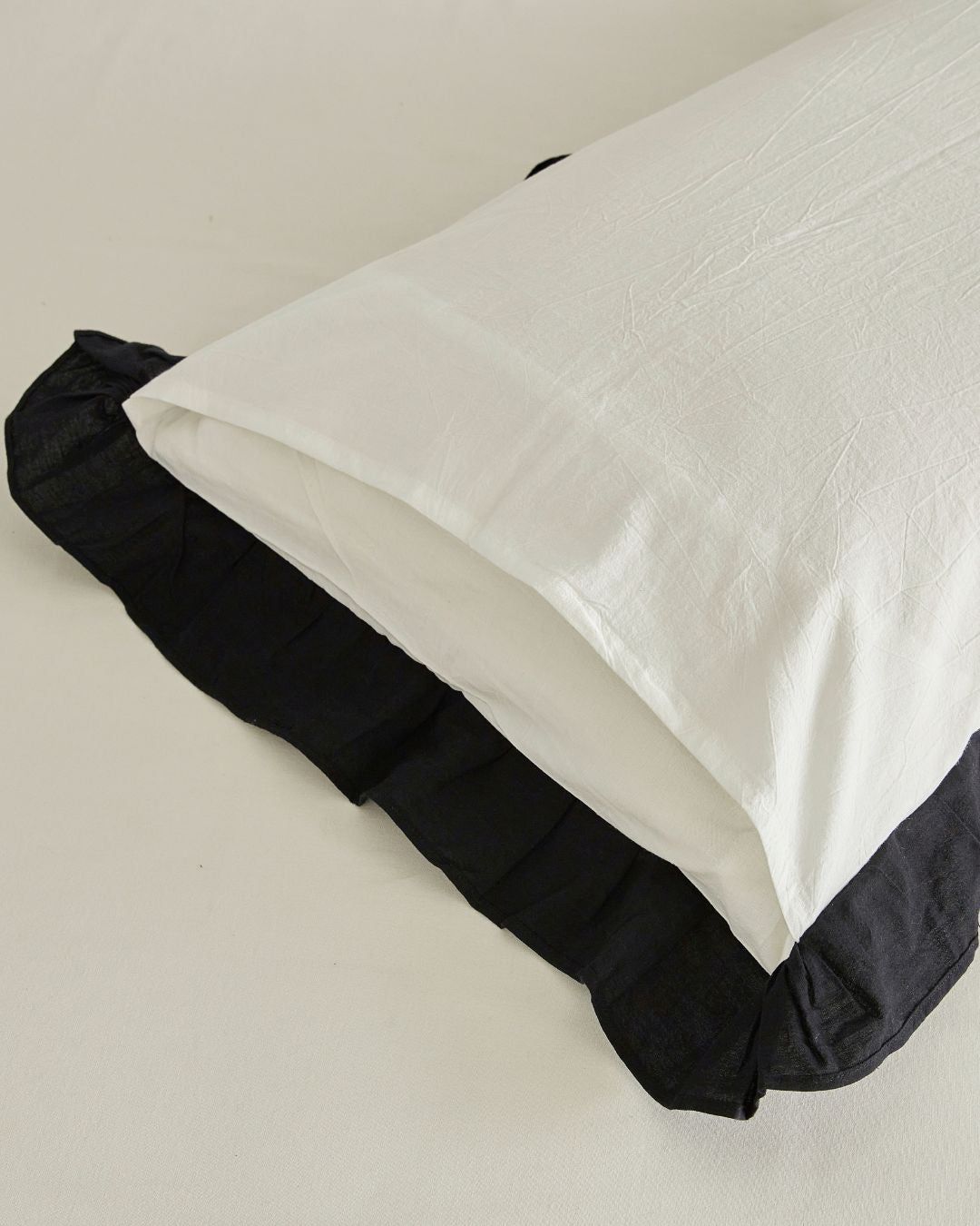 Close up detail of envelope closure pillow case withi nnerflap and black ruffle dedge