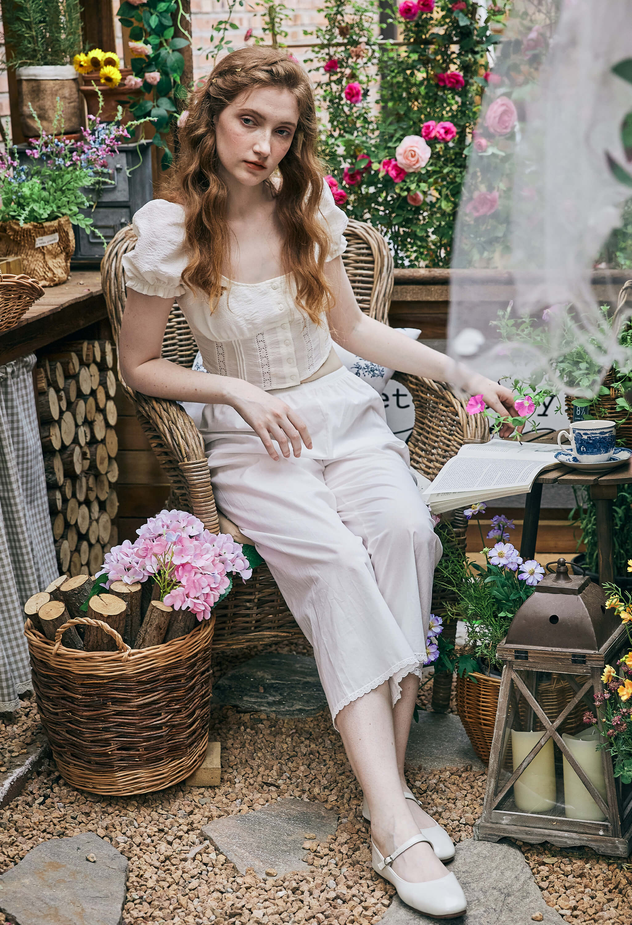 Model sitting in a garden wearing Sueasyretro Pajamas Pants. Vintage style white Bloomers for comfortable daily wear.