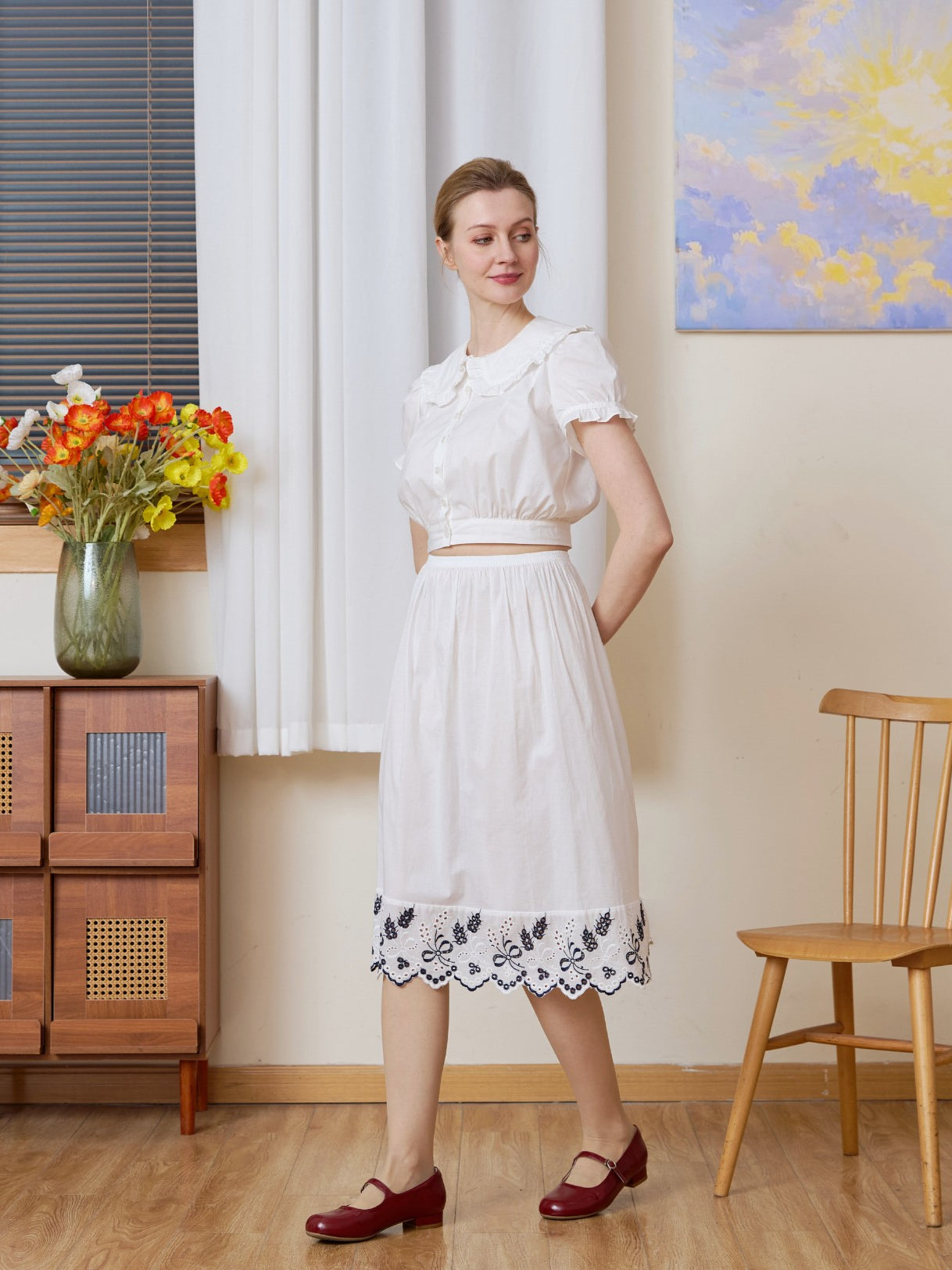 Full-body shot with a slight turn of a white cotton Petticoat with Tudor bluework, in knee length.