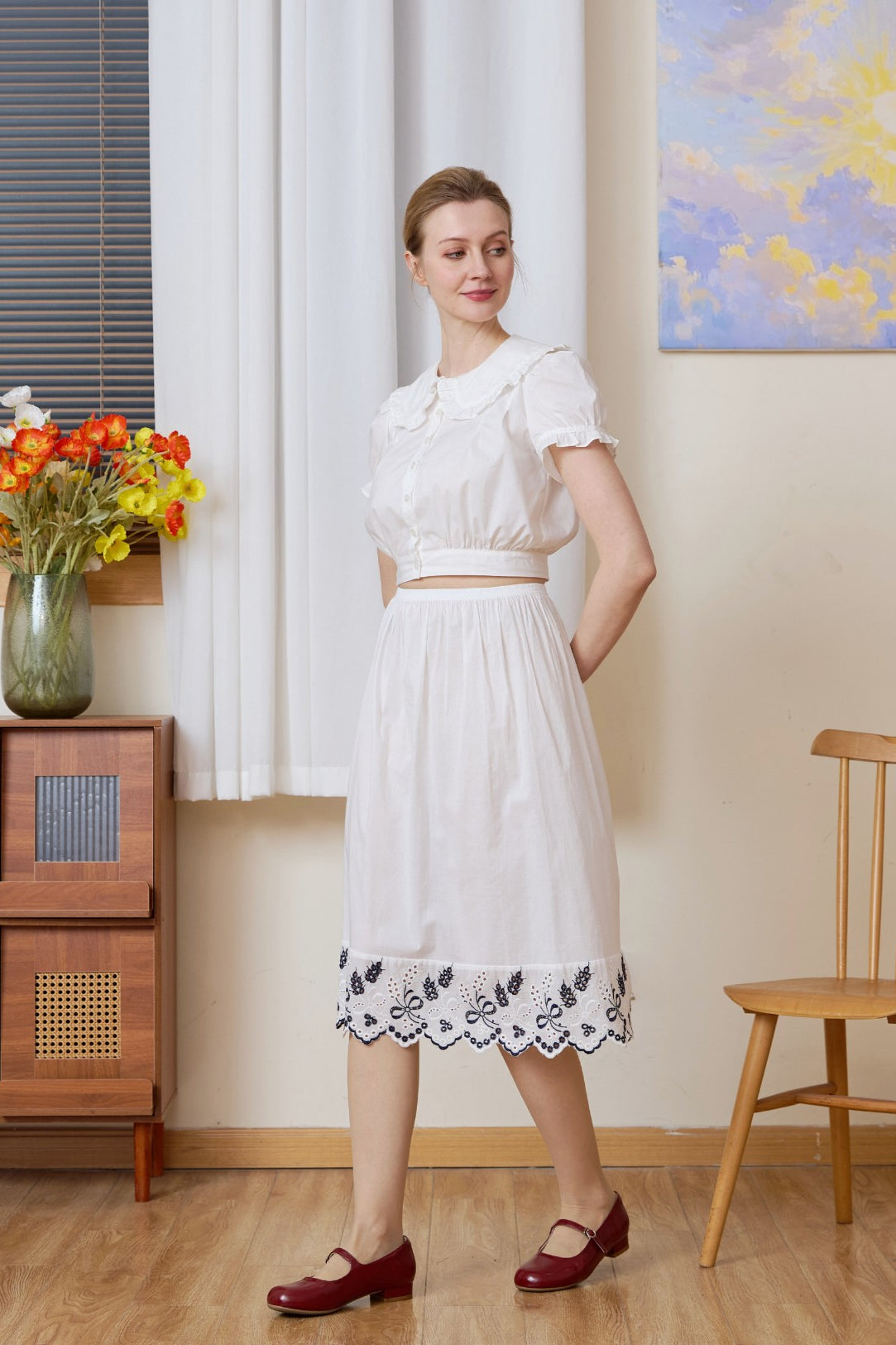 Full-body shot with a slight turn of a white cotton Petticoat with Tudor bluework, in knee length.