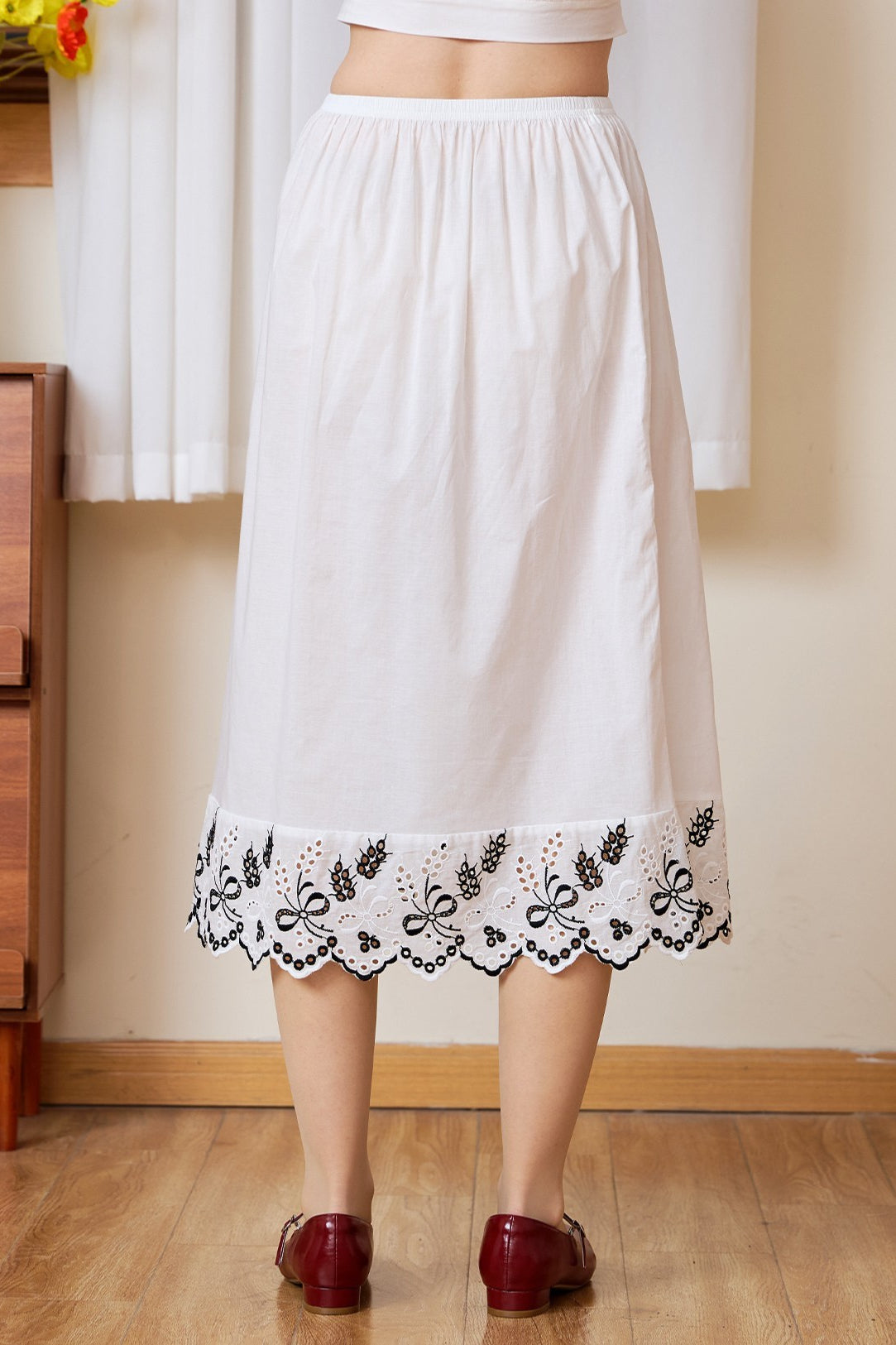Back view of the midi white cotton Petticoat with a striking bluework scalloped hem.