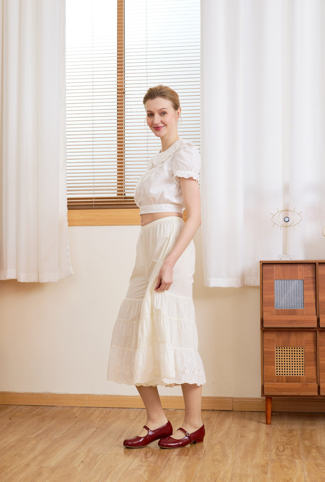 Side profile of cream bloomer pants. The voluminous tiered silhouette of these cotton bloomers offers breathable comfort.