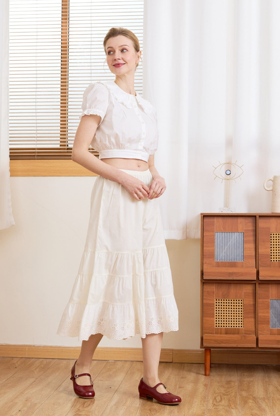 Angled view of the cream wide leg cotton bloomers. Perfect bloomer pants to wear alone or layer under a midi skirt.