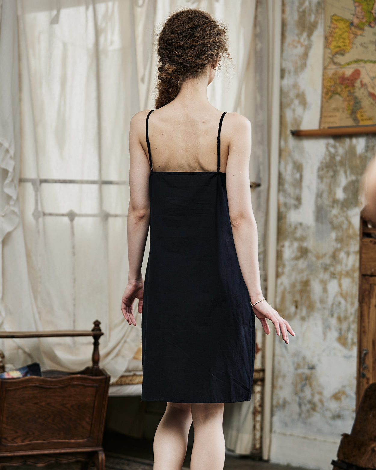 Women's black cotton full slip with spaghetti straps, showing comfortable fit and classic design - back view