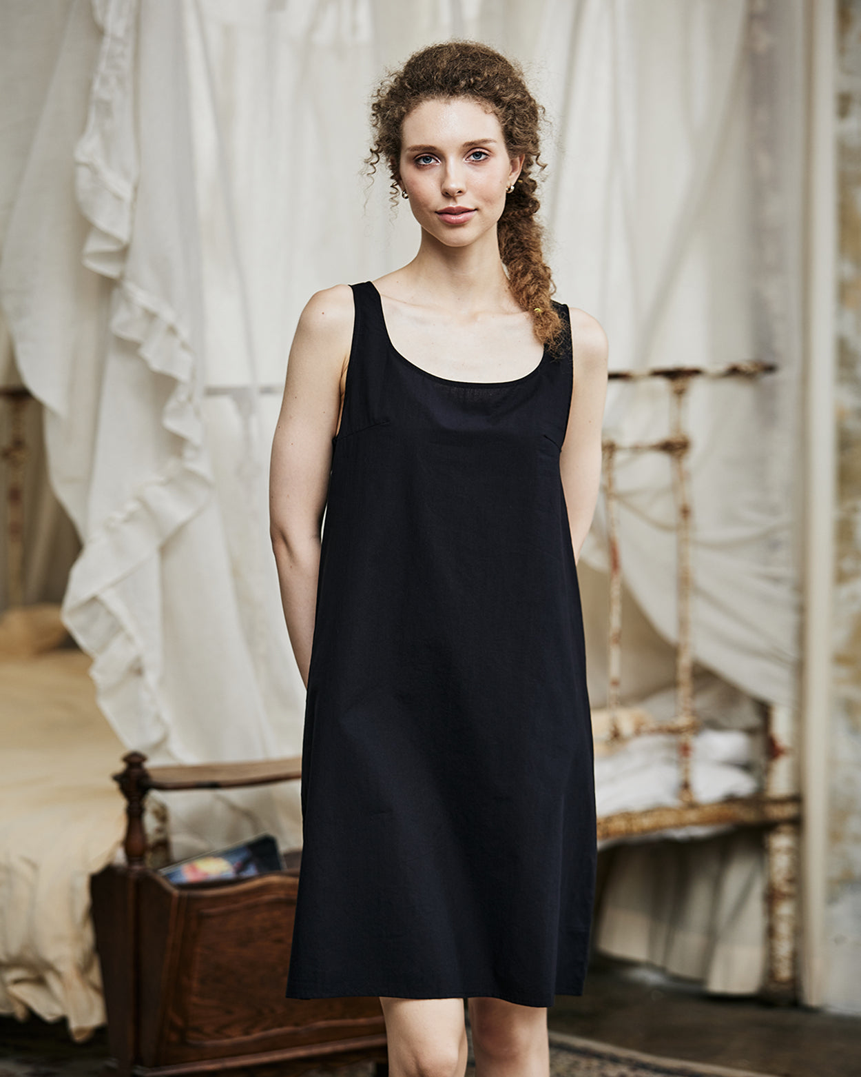 Women's black cotton full slip with wide straps, showing modesty panel and knee-length design