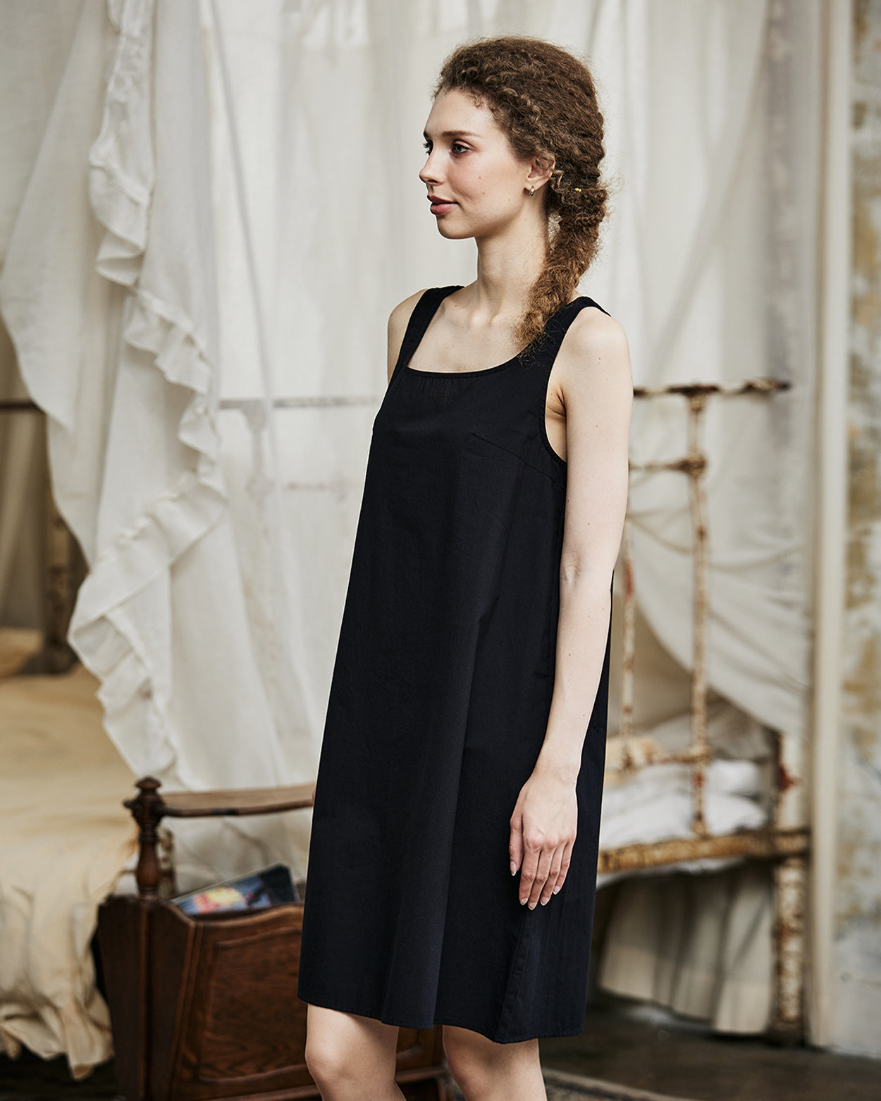 Women's black cotton full slip with wide straps, showing modesty panel and knee-length design