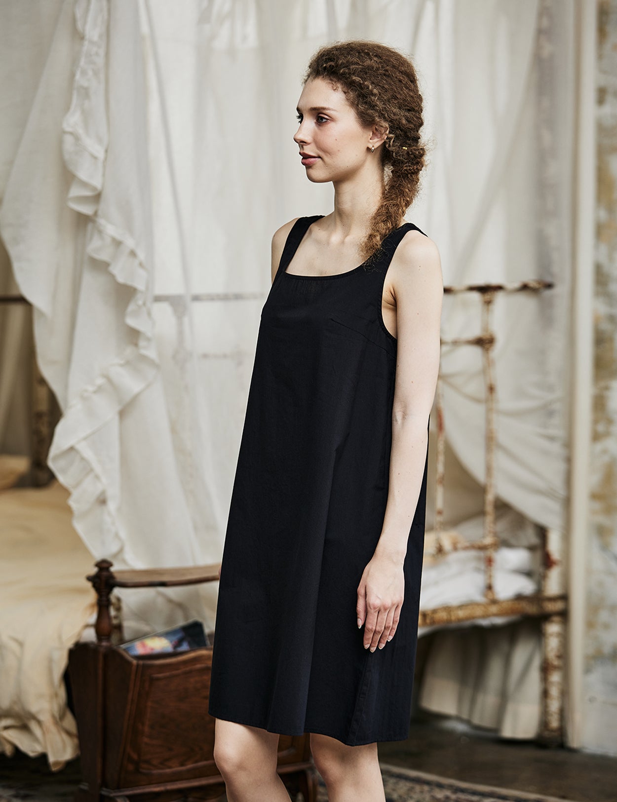 Women's black cotton full slip with wide straps, showing modesty panel and knee-length design