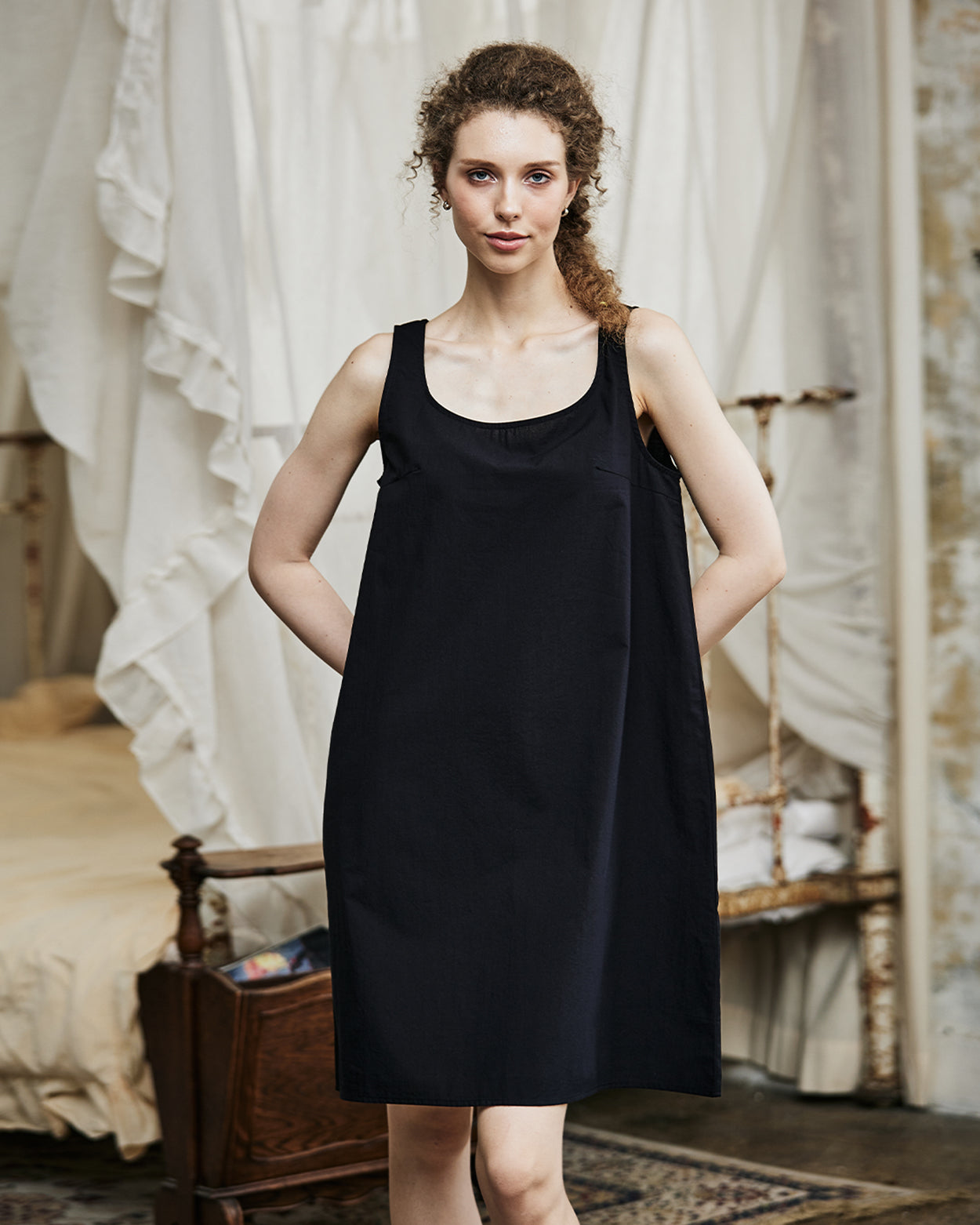 Women's black cotton full slip with wide straps, showing modesty panel and knee-length design