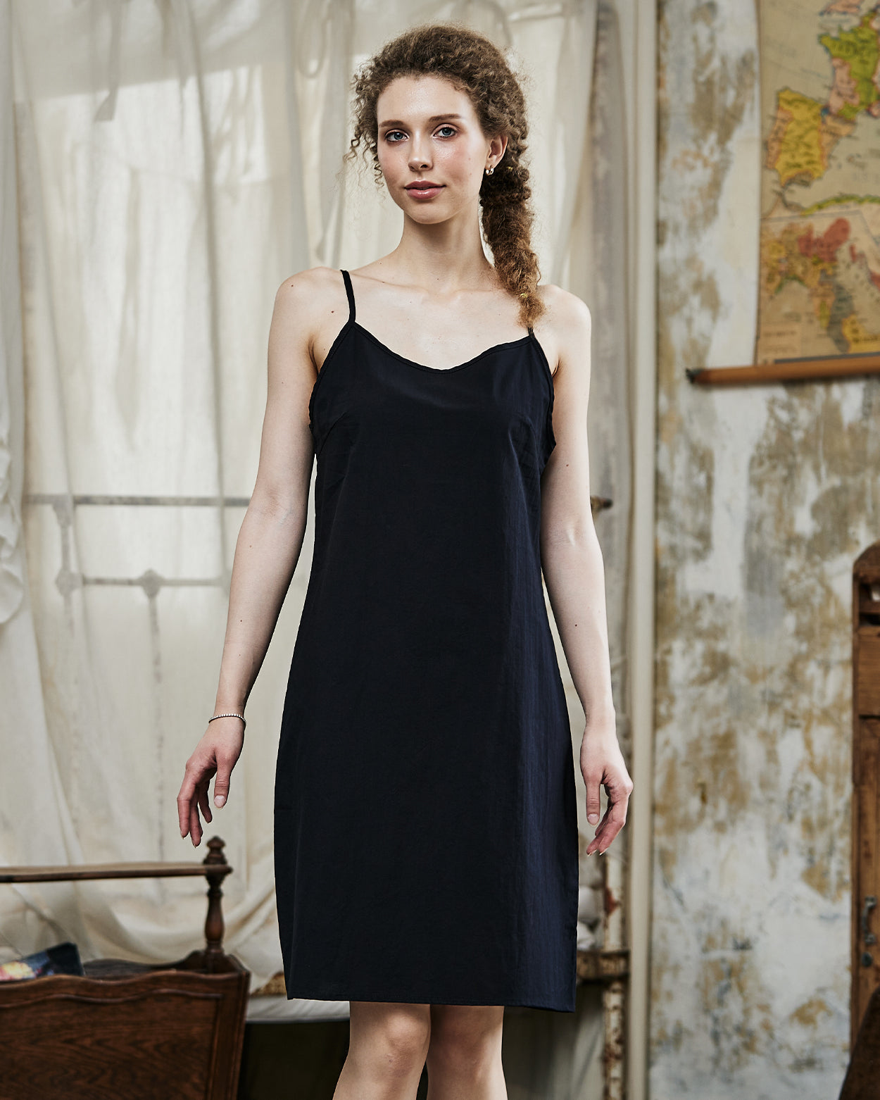 Women's black cotton full slip with spaghetti straps, showing comfortable fit and classic design