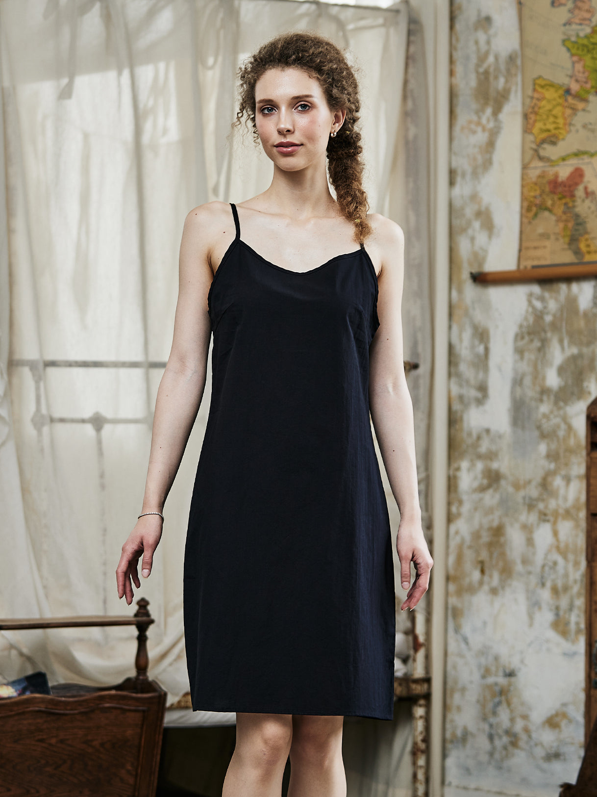 Women's black cotton full slip with spaghetti straps, showing comfortable fit and classic design