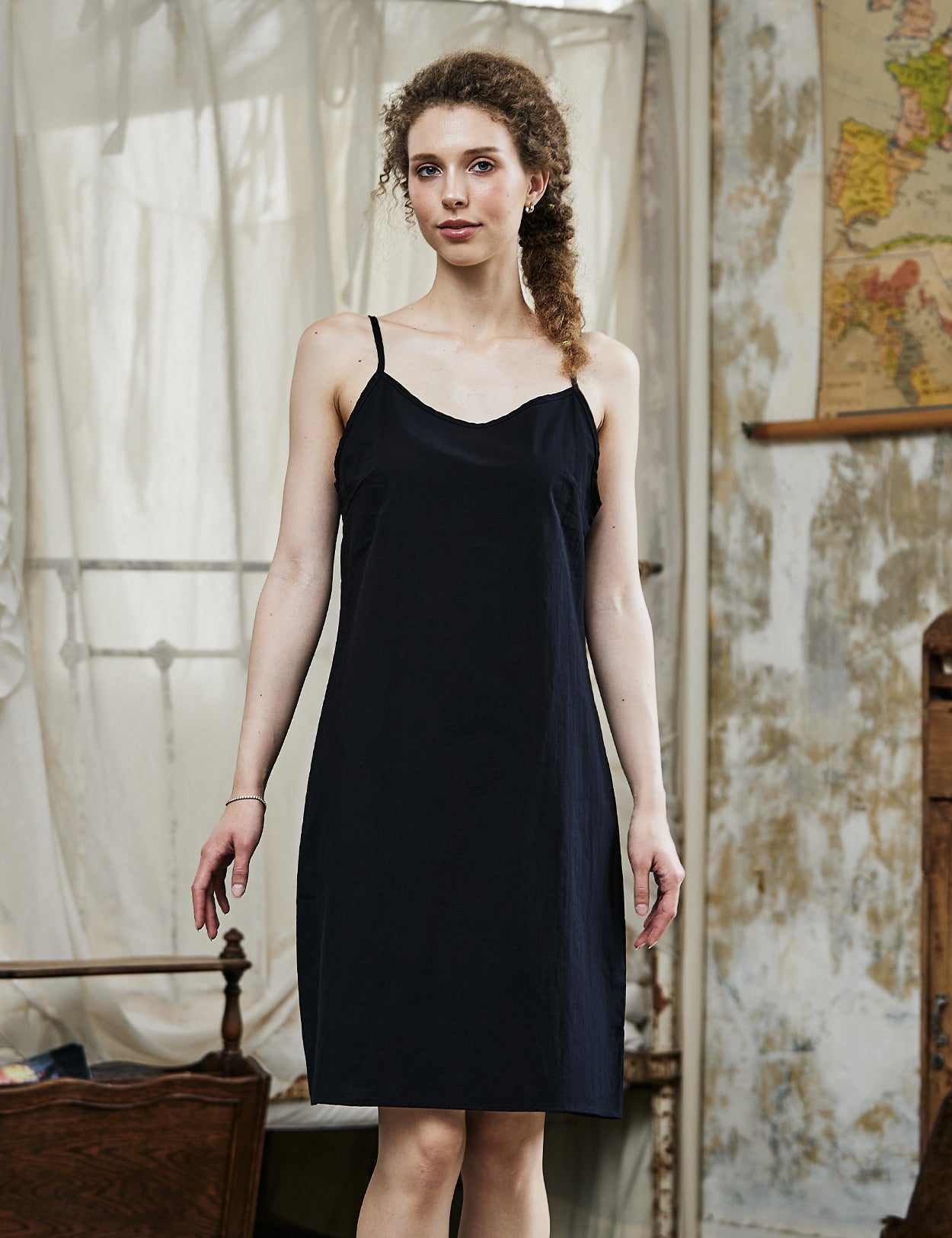 Women's black cotton full slip with spaghetti straps, showing comfortable fit and classic design