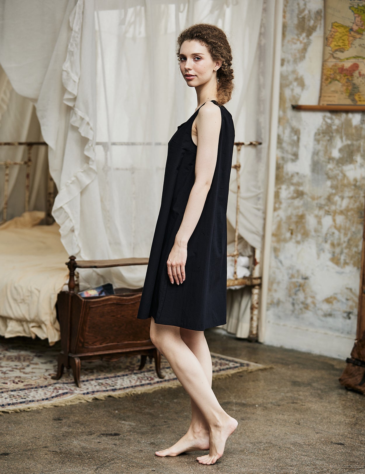 Women's black cotton full slip with wide straps, showing modesty panel and knee-length design - back view