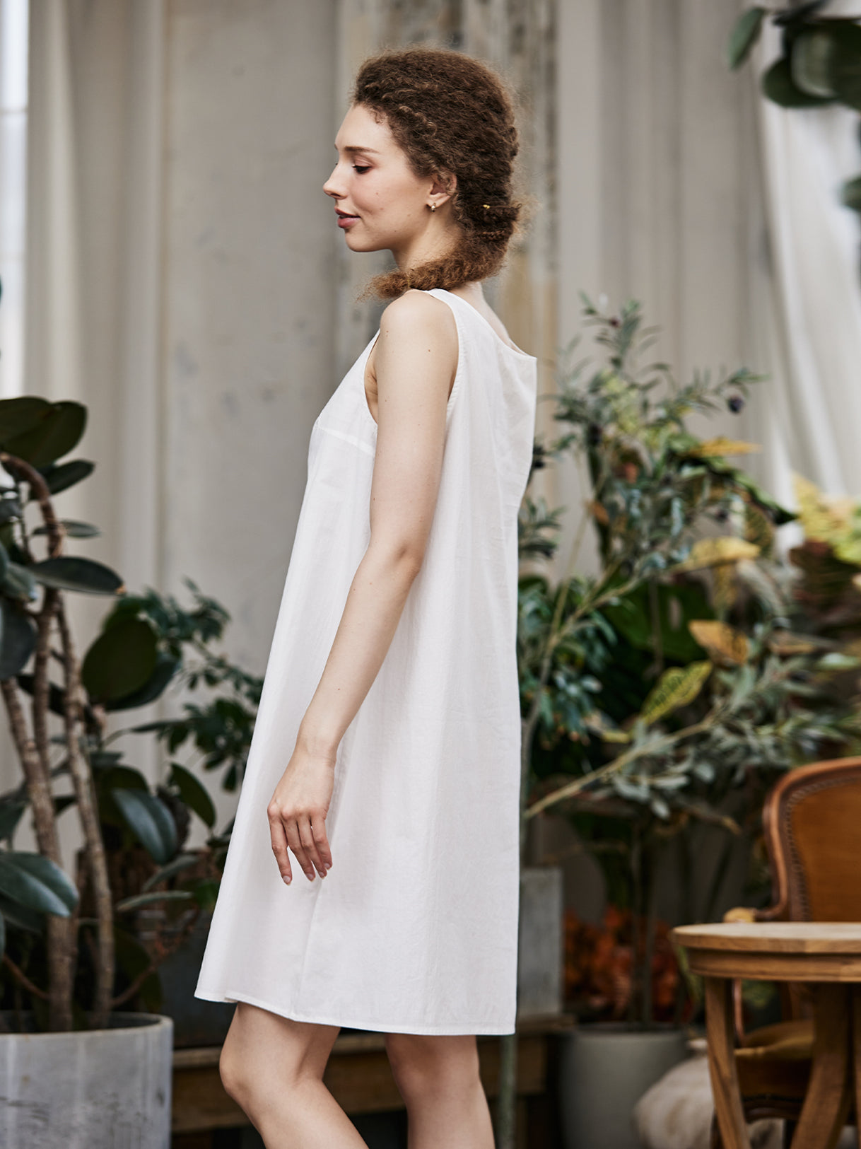 Women's white cotton full slip with wide straps, showing modesty panel and knee-length design - side view