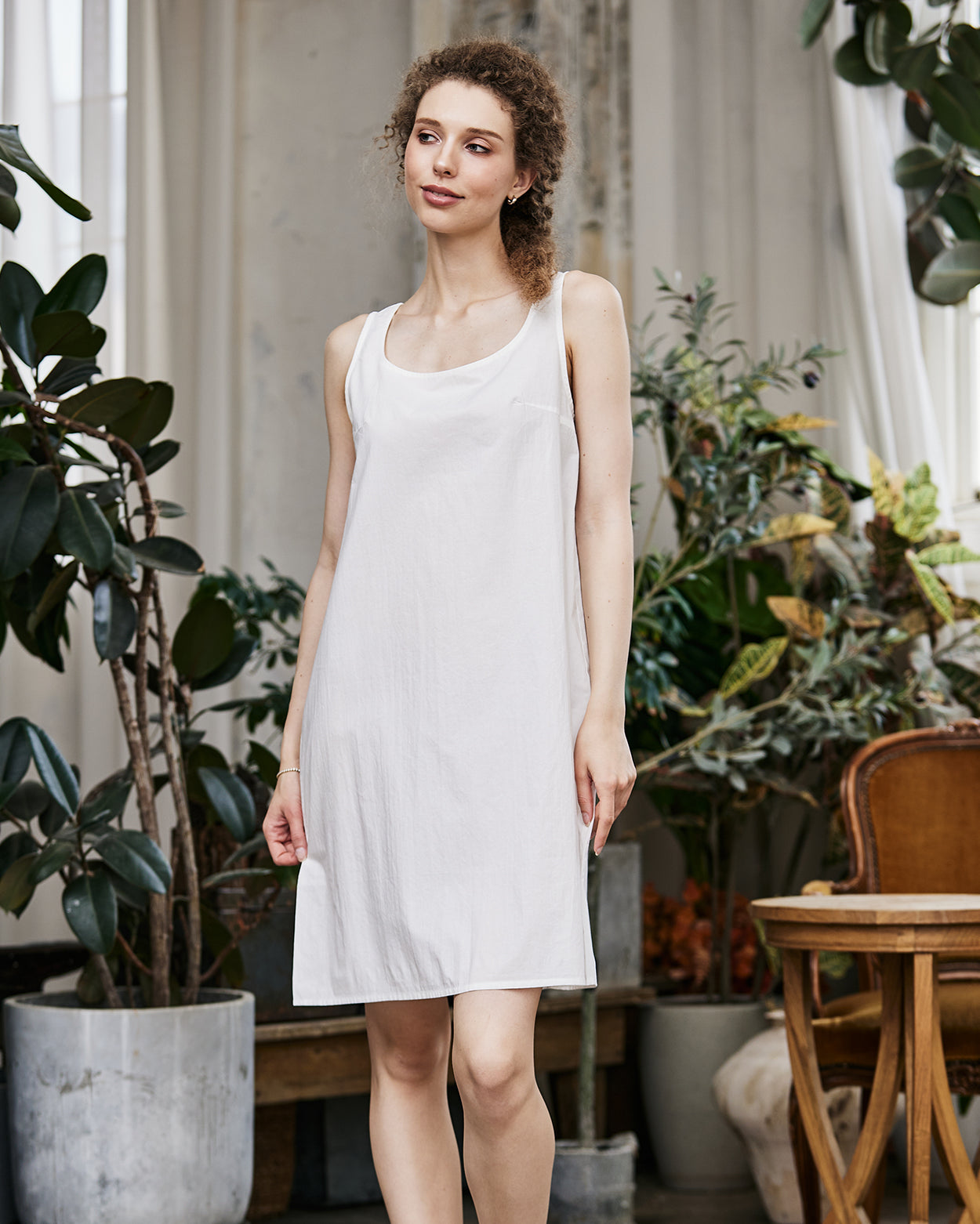 Women's white cotton full slip with wide straps, showing modesty panel and knee-length design
