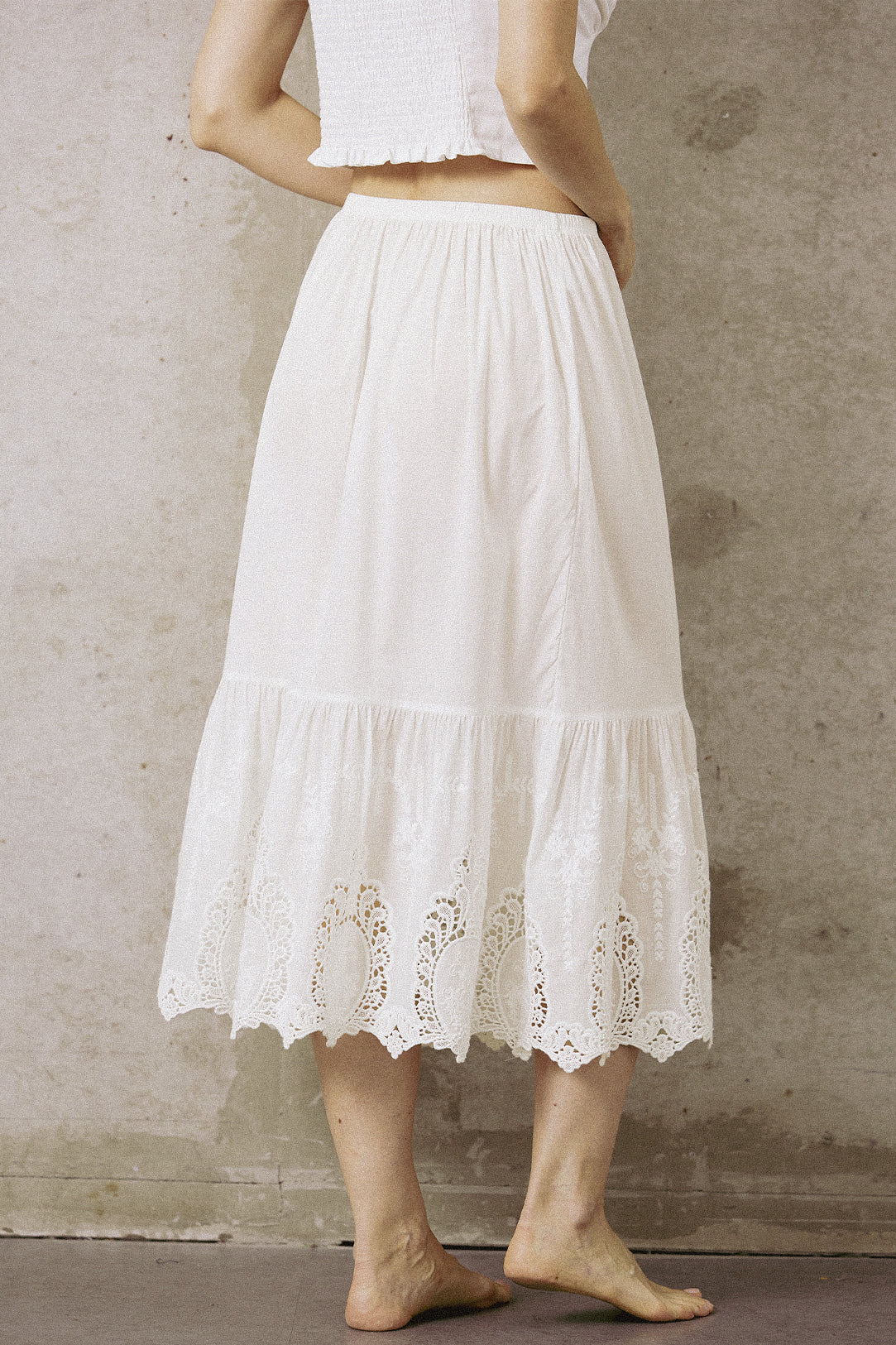 Back view of the mid-length white cotton half slip, showing the breathable fabric and ruffled lace hem design.