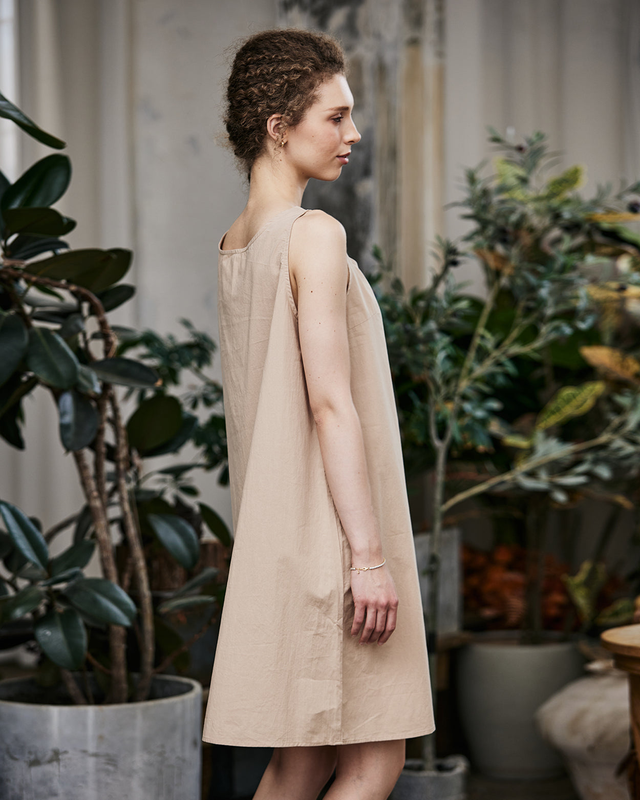 Women's nude cotton full slip with wide straps, showing modesty panel and knee-length design - side view