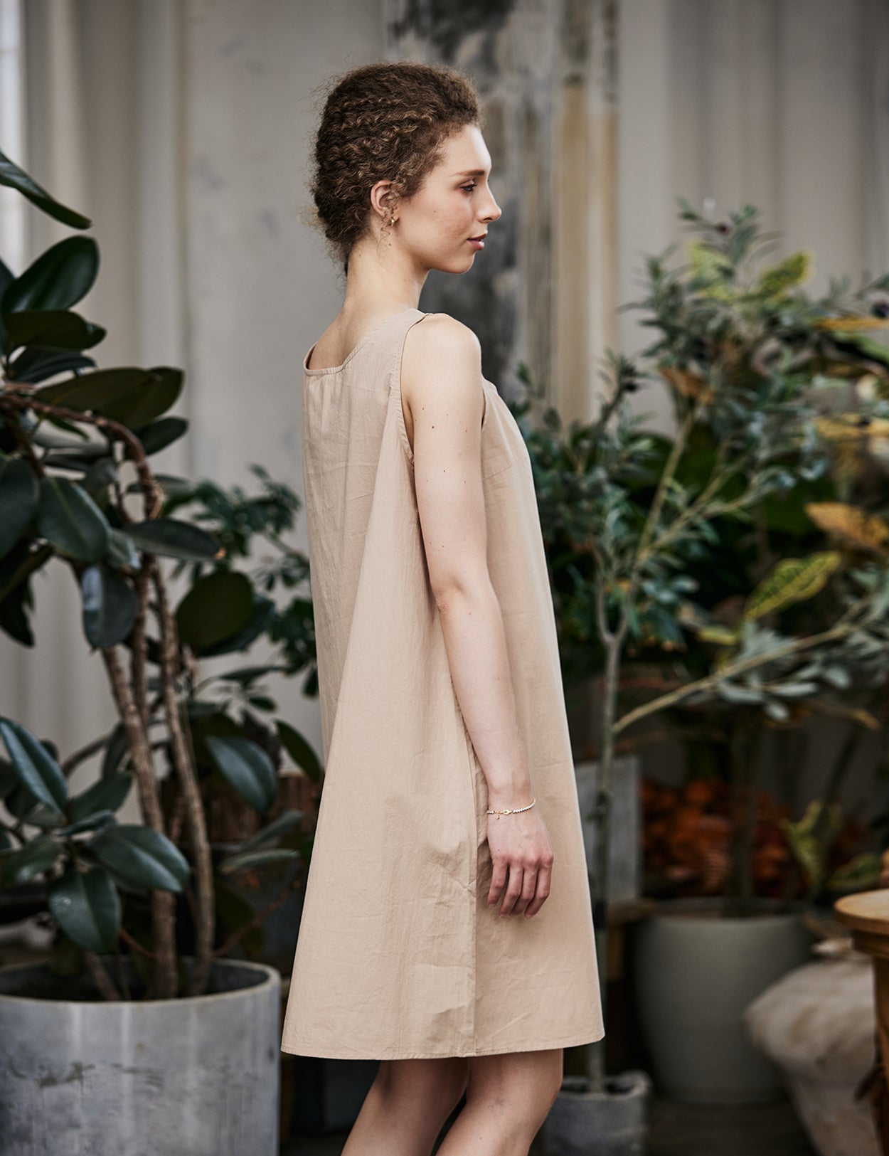 Women's nude cotton full slip with wide straps, showing modesty panel and knee-length design - side view