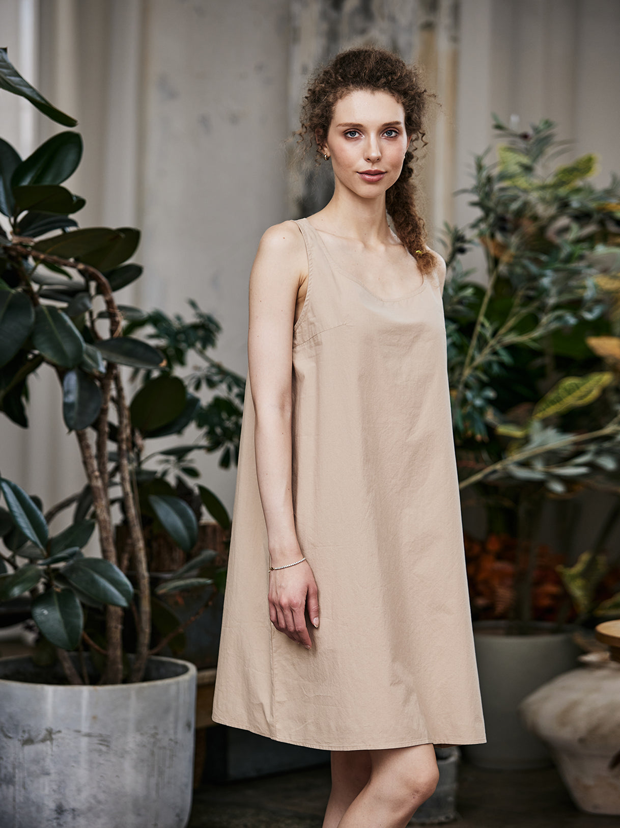 Women's nude cotton full slip with wide straps, showing modesty panel and knee-length design