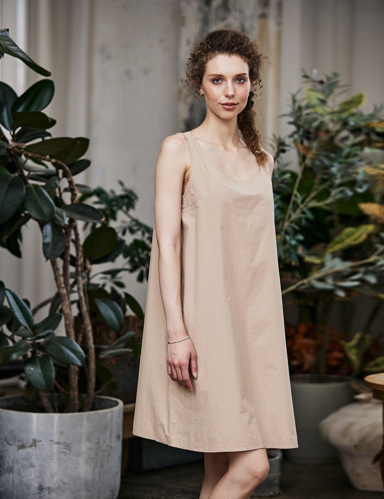 Women's nude cotton full slip with wide straps, showing modesty panel and knee-length design