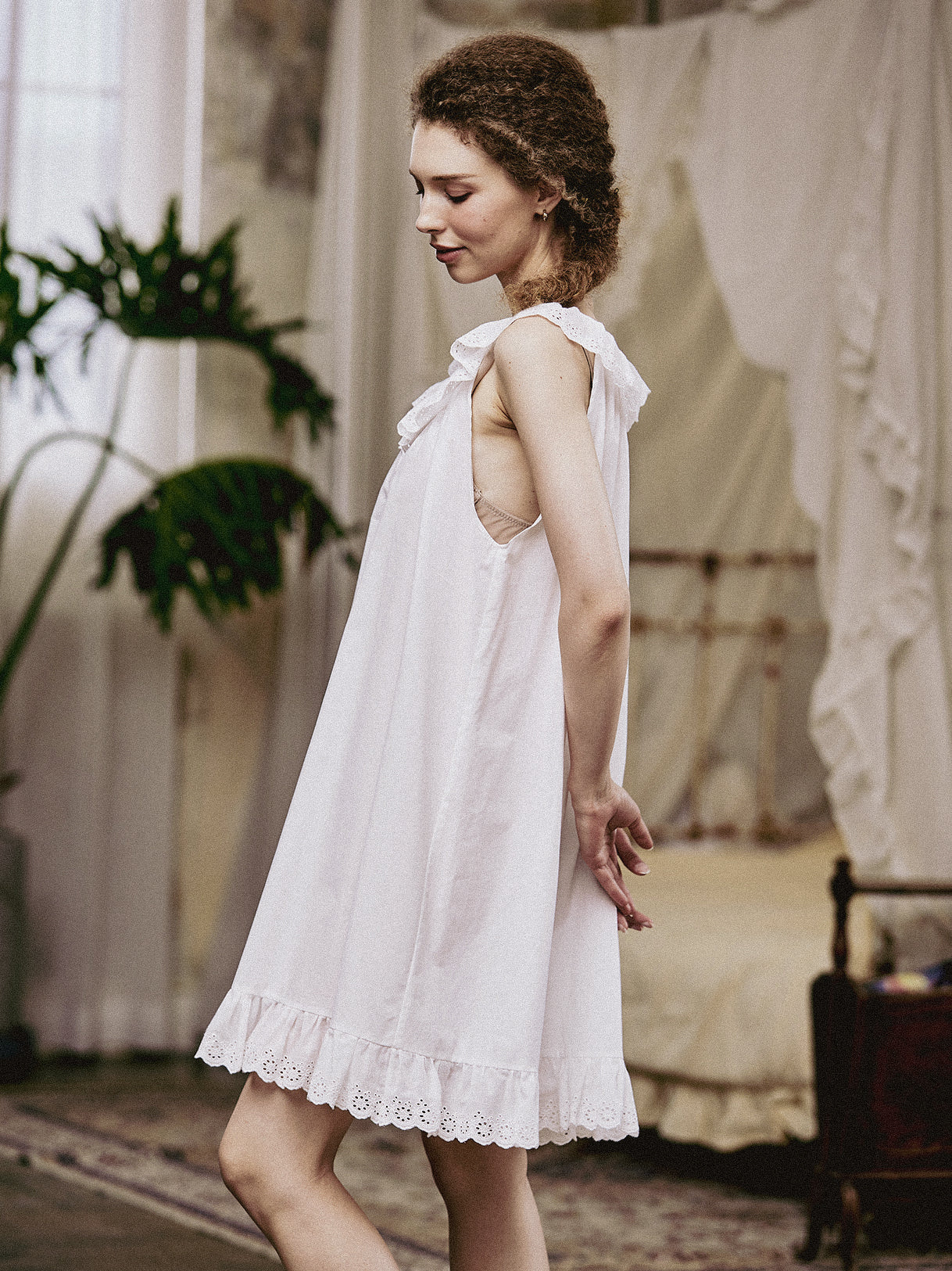 Side profile of the short cotton sleep dress featuring delicate Broderie Anglaise embroidery and a loose, comfortable fit.