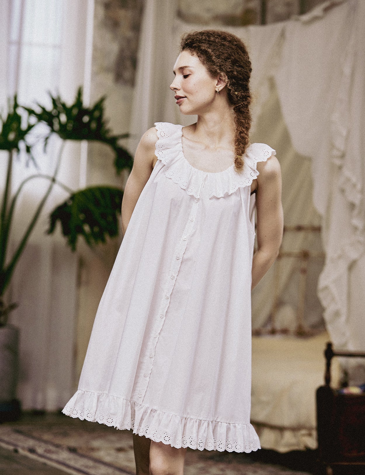 Lifestyle shot of a model in a sleeveless white Victorian-style nightgown, highlighting its breathable summer fabric.