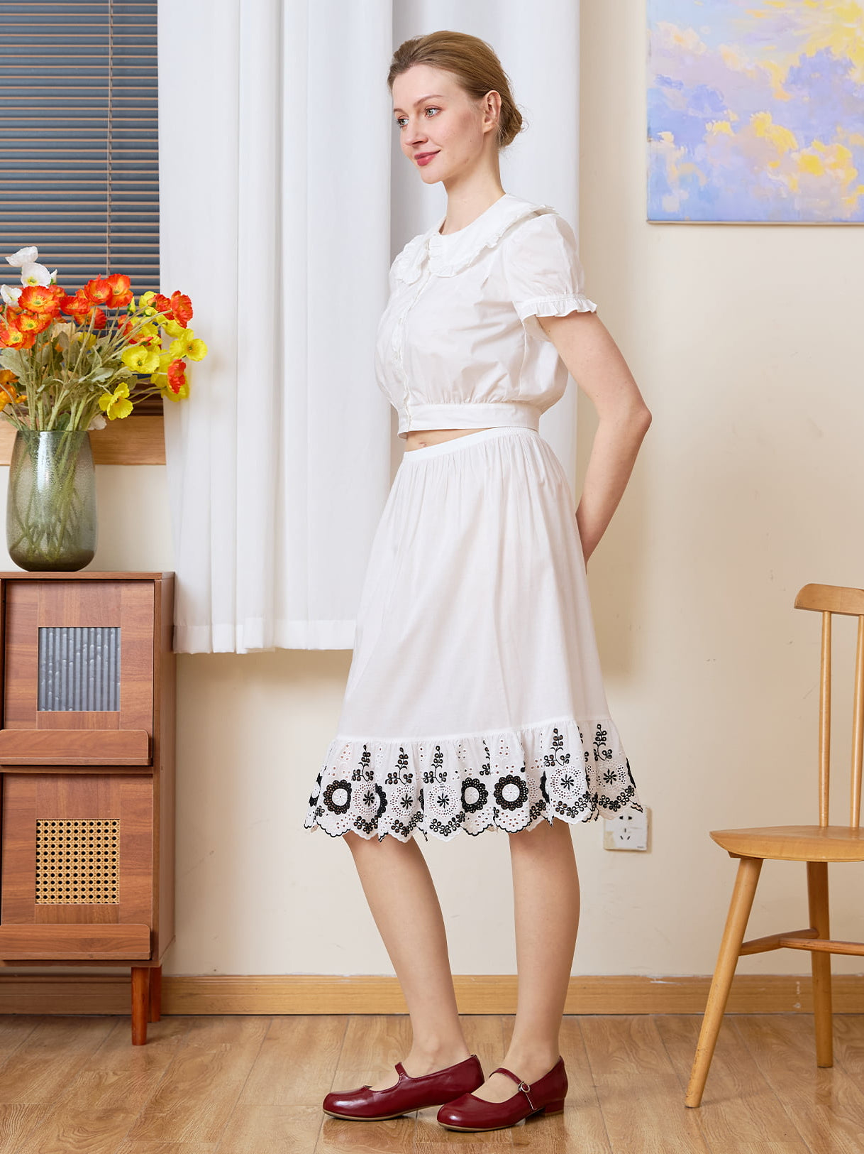 Sueasyretro Cotton Skirt Extender: full body side view of white slip with black floral ruffle hem and vintage styling.