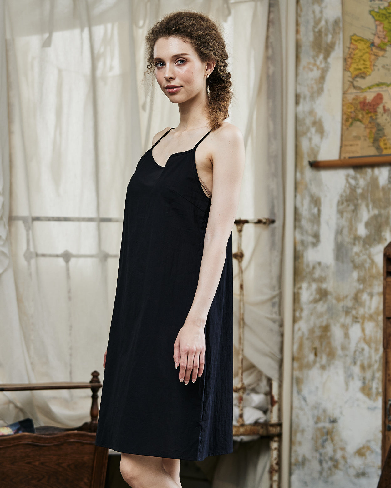 Women's black cotton full slip with spaghetti straps, showing comfortable fit and classic design