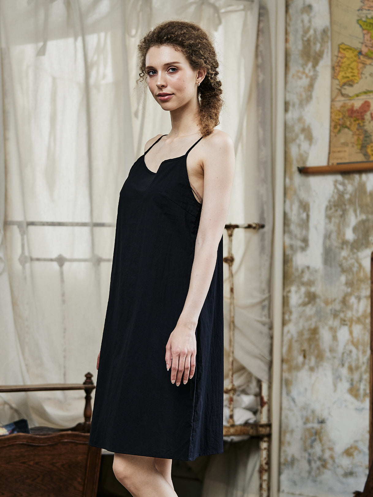 Women's black cotton full slip with spaghetti straps, showing comfortable fit and classic design