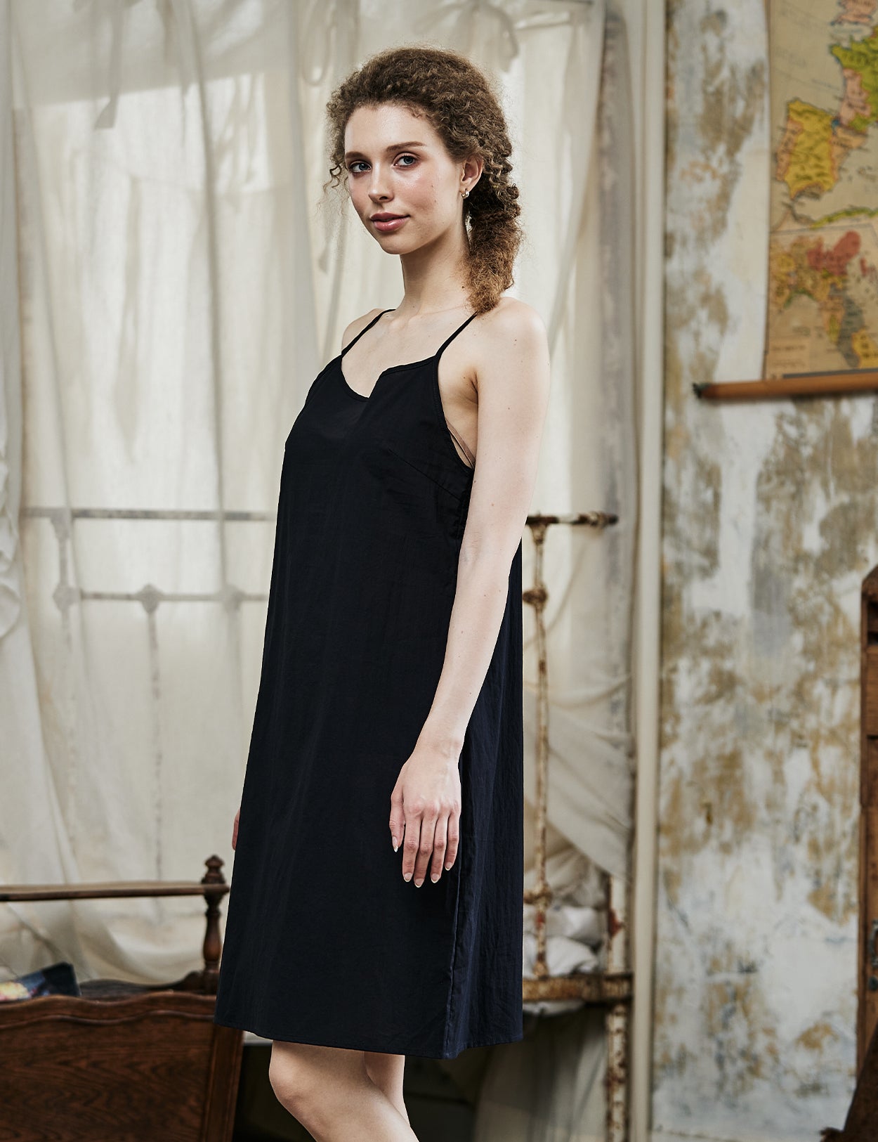 Women's black cotton full slip with spaghetti straps, showing comfortable fit and classic design