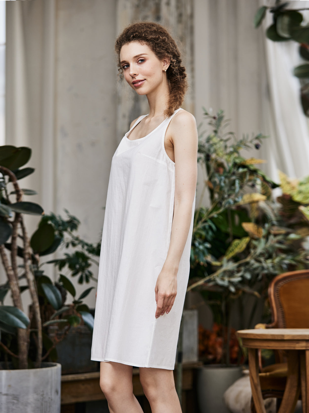 Women's white cotton full slip with wide straps, showing modesty panel and knee-length design