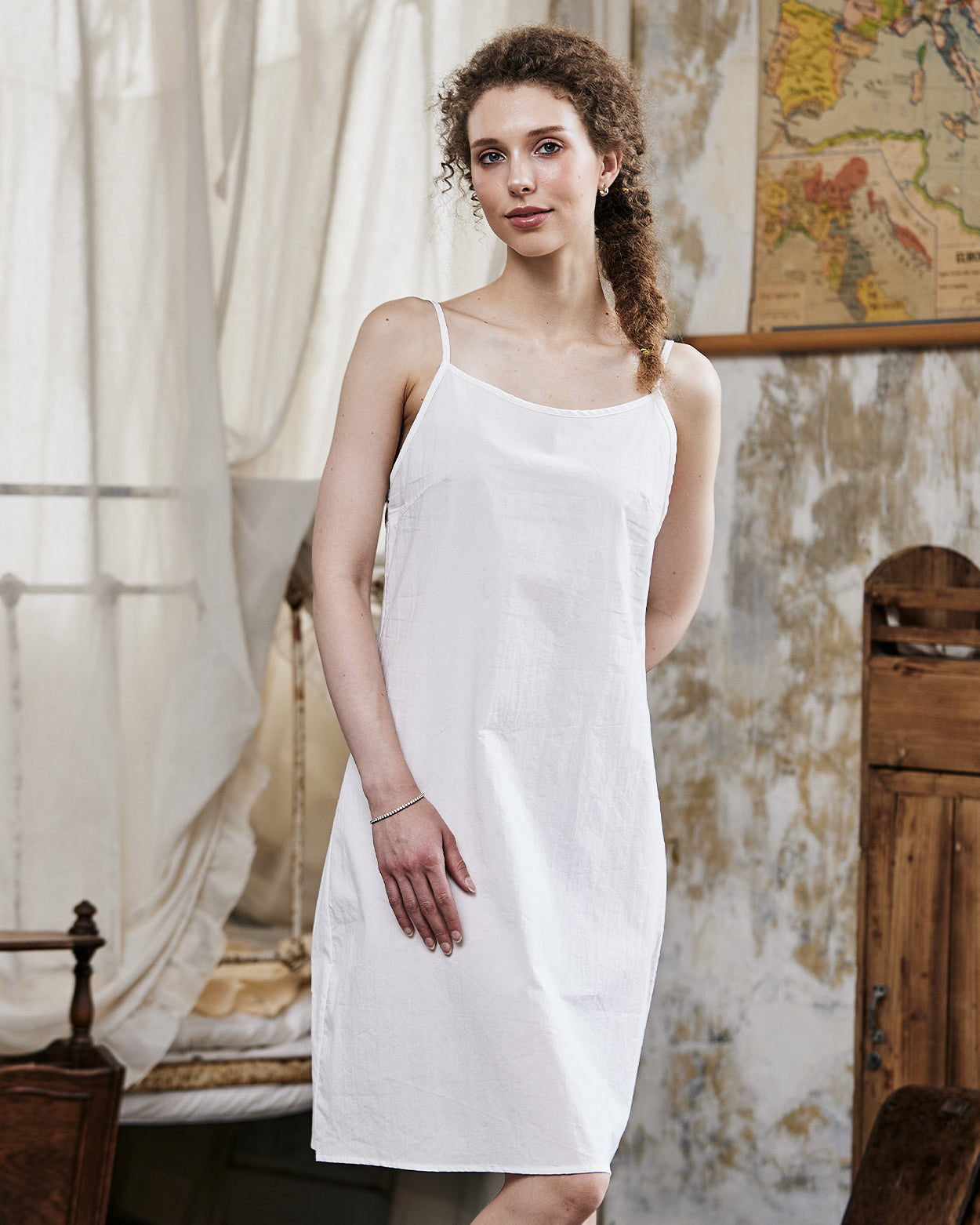 Women's white cotton full slip with spaghetti straps, showing comfortable fit and classic design