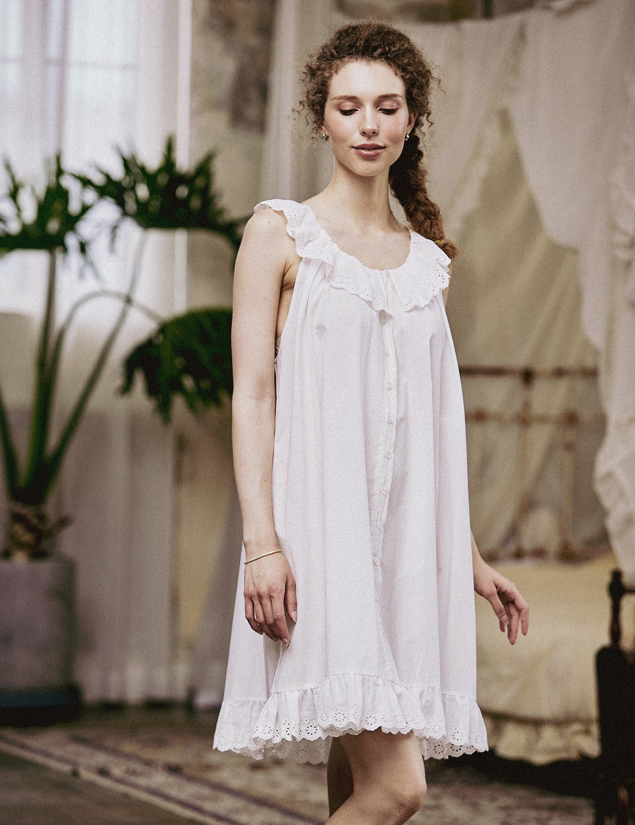 Full front view of a women's sleeveless short Victorian nightgown in white cotton with a ruffled lace neckline.