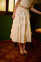 Front view of a woman wearing an ivory 100% cotton Victorian underskirt half slip, showcasing the 3-tier ruffled A-line silhouette and delicate lace trim.