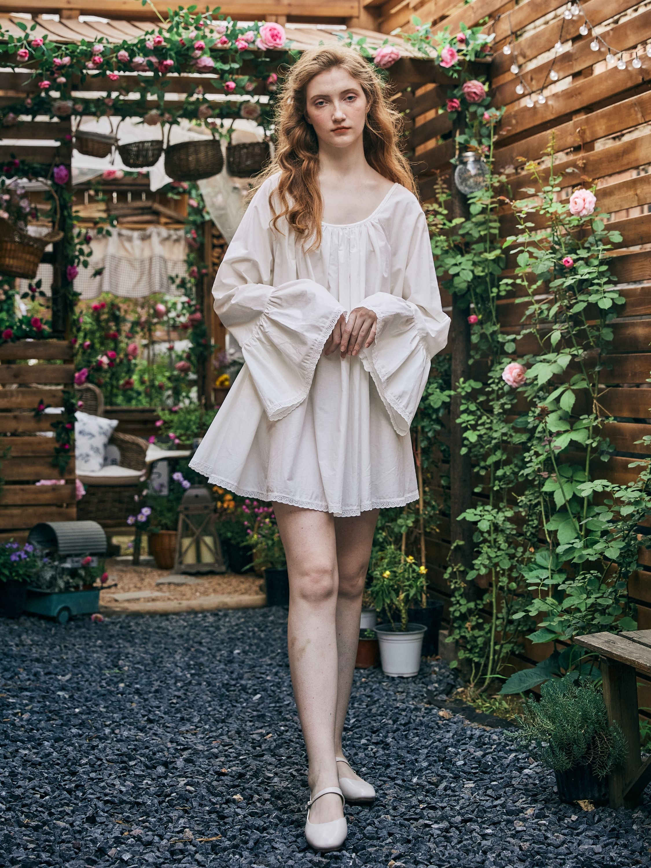Front view of a white Victorian chemise style cotton short nightgown for women, featuring wide bell sleeves and delicate lace trim.