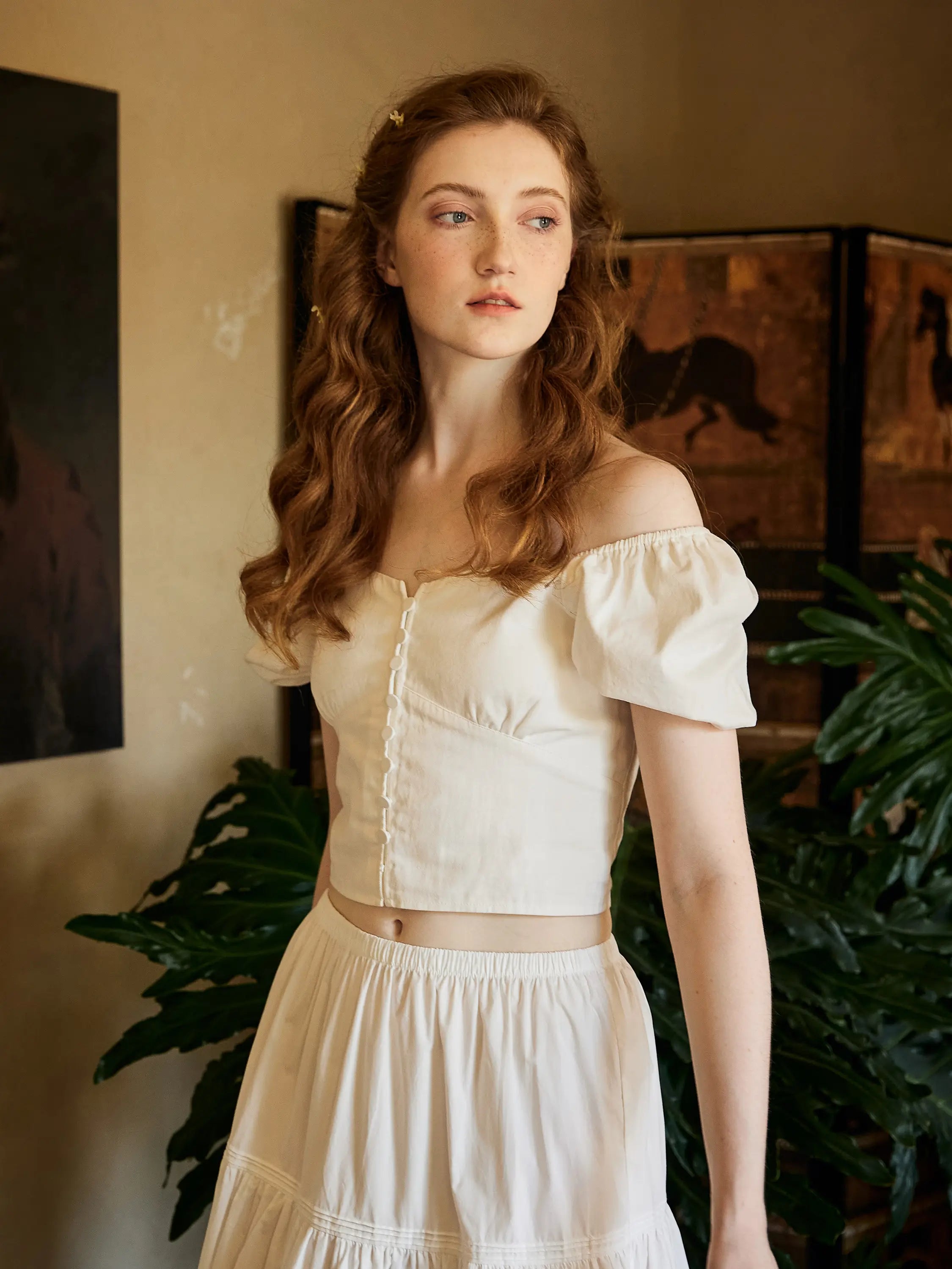 Close-up of Sueasyretro white cotton crop top with off-the-shoulder puff sleeves, worn with a gathered white midi skirt for a romantic retro style.