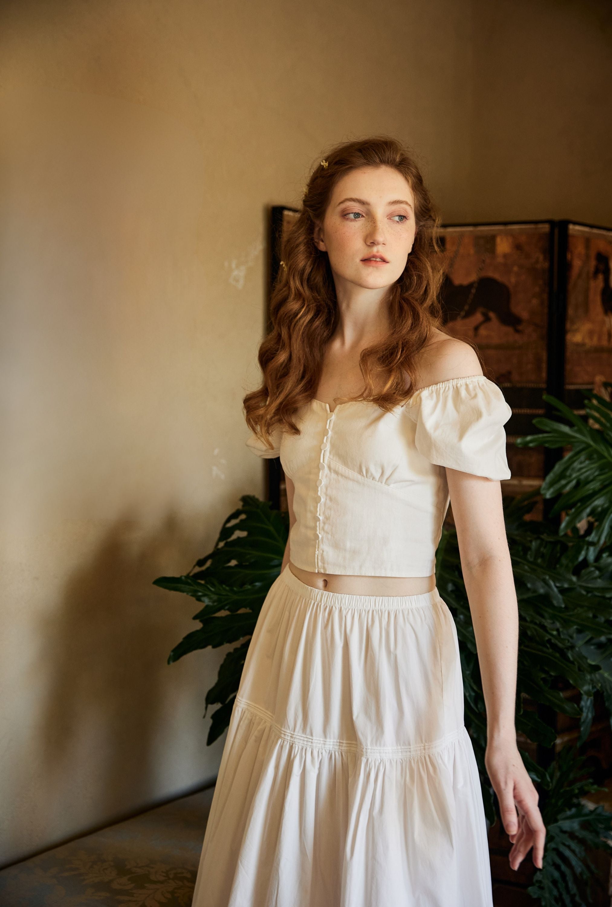 Woman wearing a Neo-classical inspired lightweight white cotton maxi skirt with a comfortable flexible elastic waistband, styled with a vintage top.