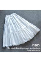 Ivory 100% cotton petticoat half slip laid flat, showcasing the voluminous pleated A-line silhouette and delicate lace hem.