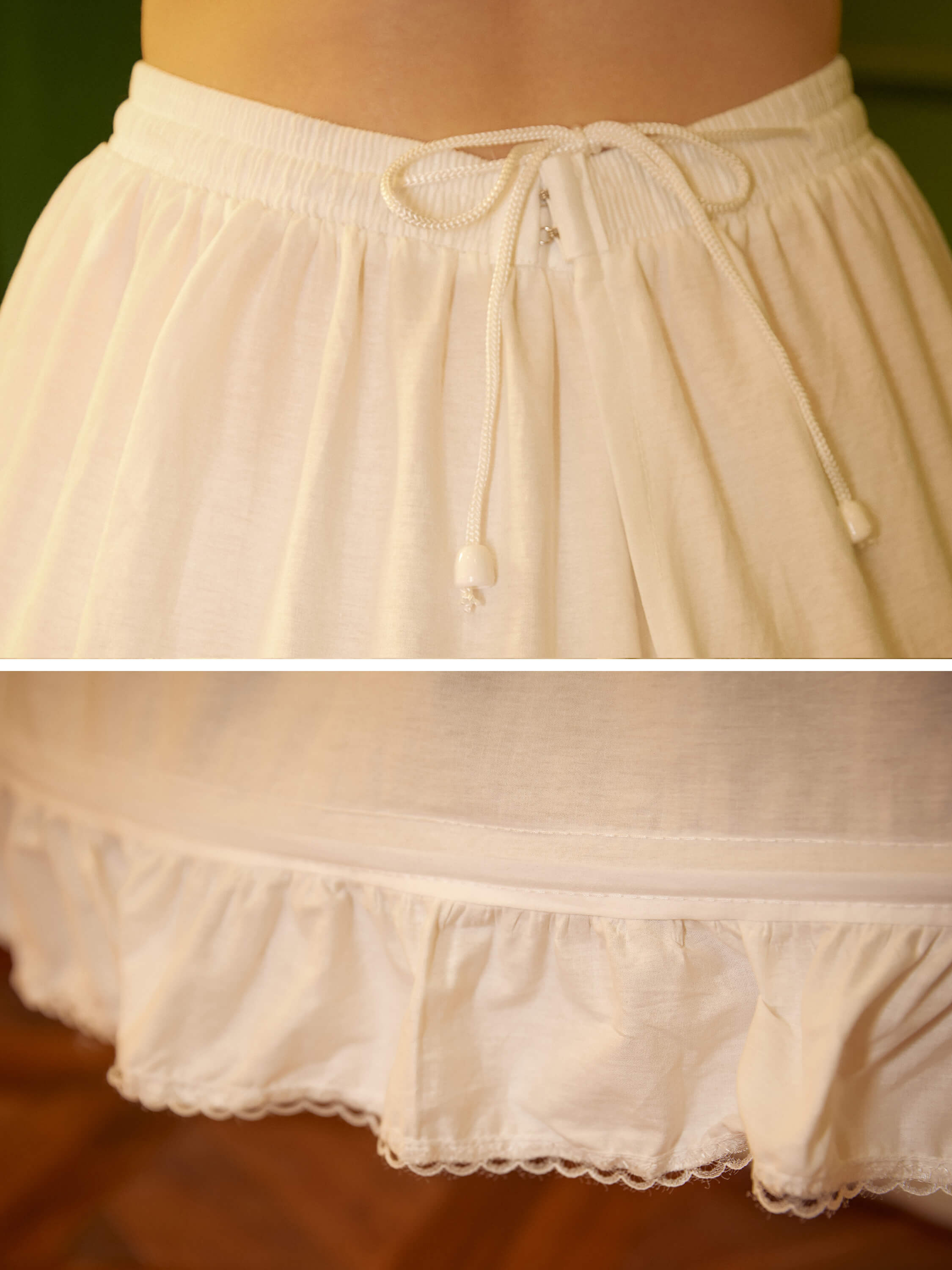 Close-up detail of the adjustable waistband on the ivory cotton hoop petticoat, featuring the elastic band, button hooks, and drawstring for a secure fit.