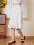 Side view of an Ivory cotton petticoat with a flexible elastic waist and a graceful A-line silhouette for daily layering.