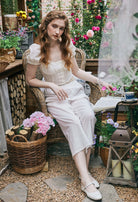 Model sitting in a garden wearing Sueasyretro Pajamas Pants. Vintage style white Bloomers for comfortable daily wear.