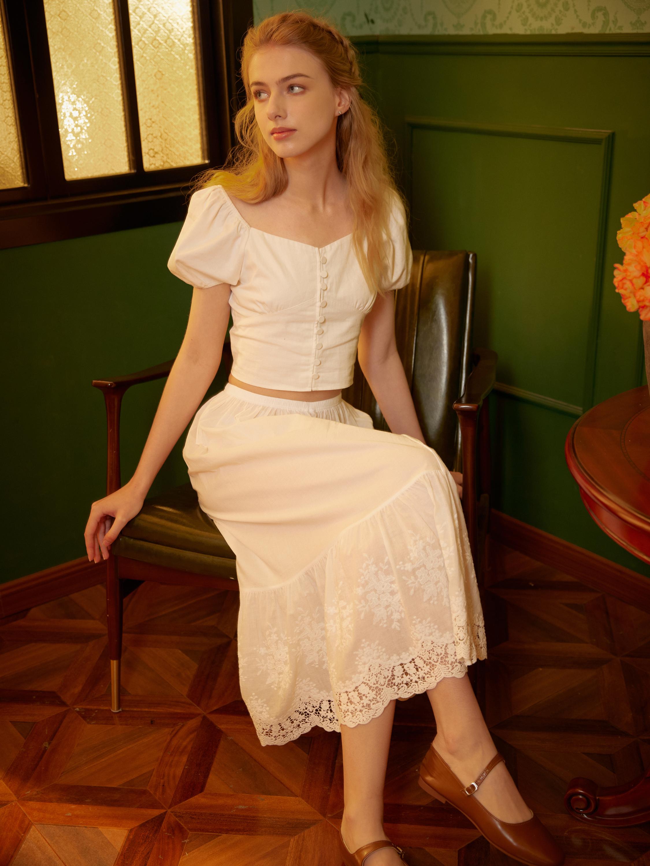 Front seated view displaying the intricate floral embroidery of the cotton petticoat lace.