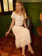 Front seated view displaying the intricate floral embroidery of the cotton petticoat lace.