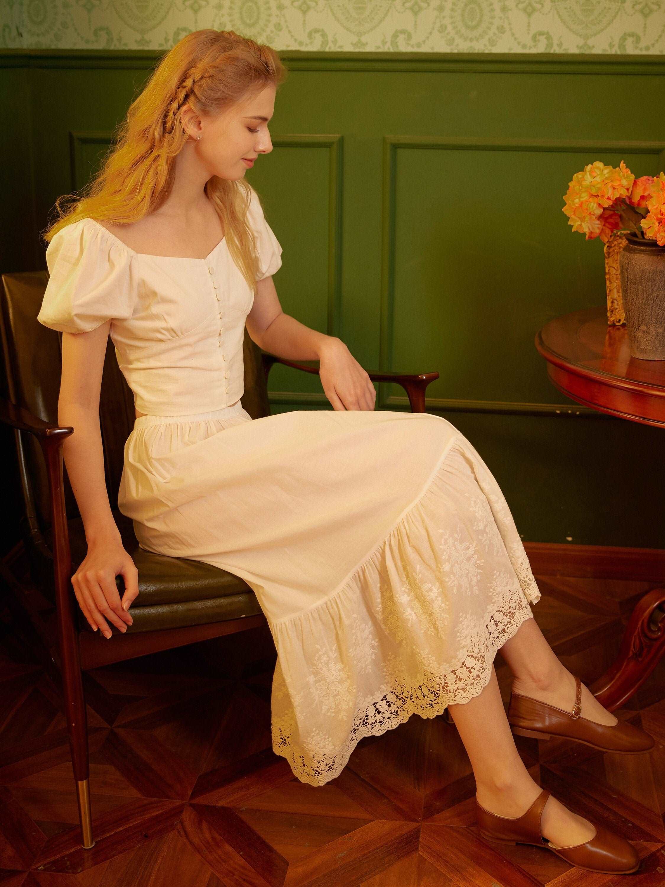 Model sitting sideways to show the elegant drape of the vintage cotton petticoat lace.