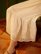 Close-up of the elegant cotton petticoat lace hem, displaying detailed floral embroidery.