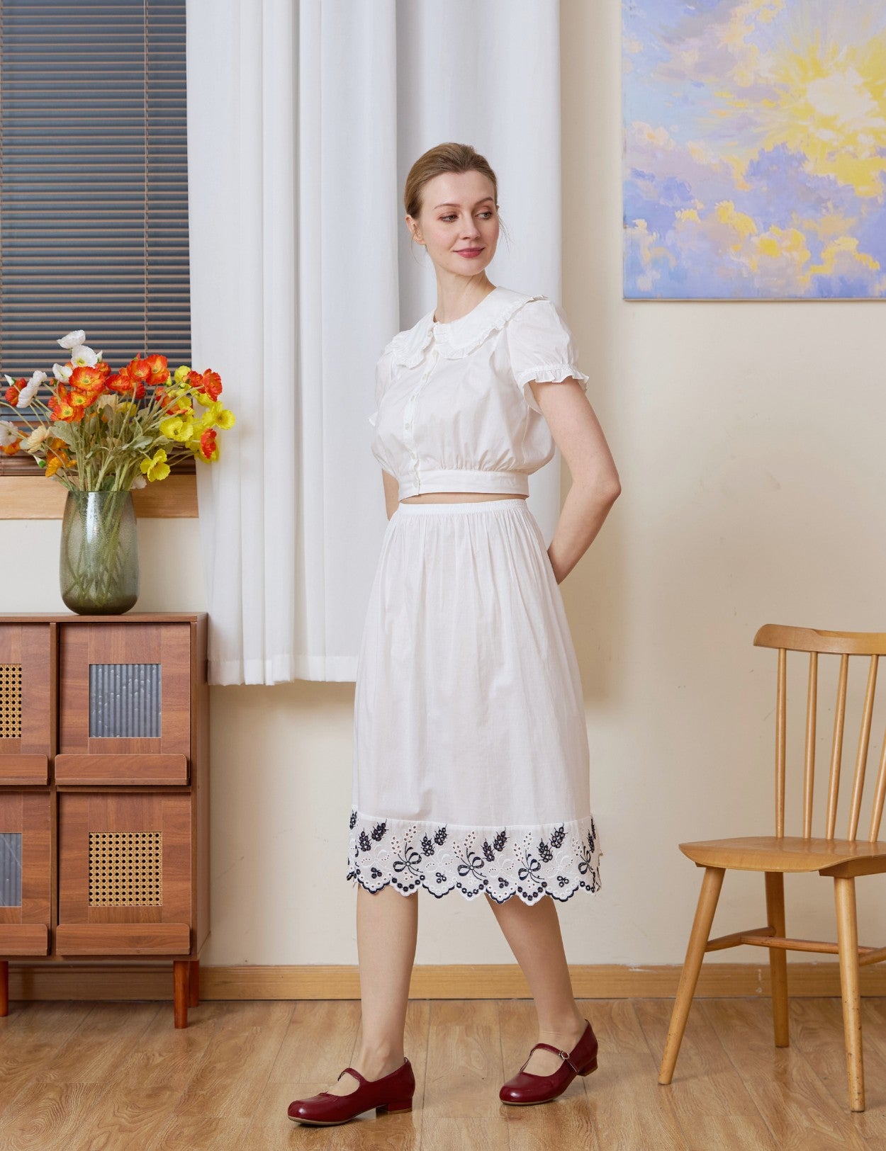 Full-body shot with a slight turn of a white cotton Petticoat with Tudor bluework, in knee length.