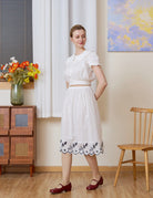 Full-body shot with a slight turn of a white cotton Petticoat with Tudor bluework, in knee length.