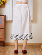 Back view of the midi white cotton Petticoat with a striking blackwork scalloped hem.