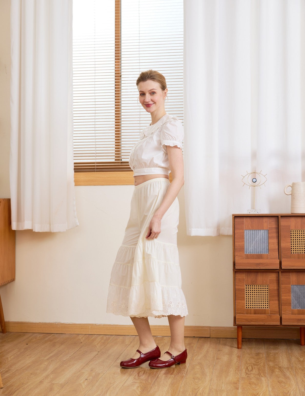 Side profile of cream bloomer pants. The voluminous tiered silhouette of these cotton bloomers offers breathable comfort.