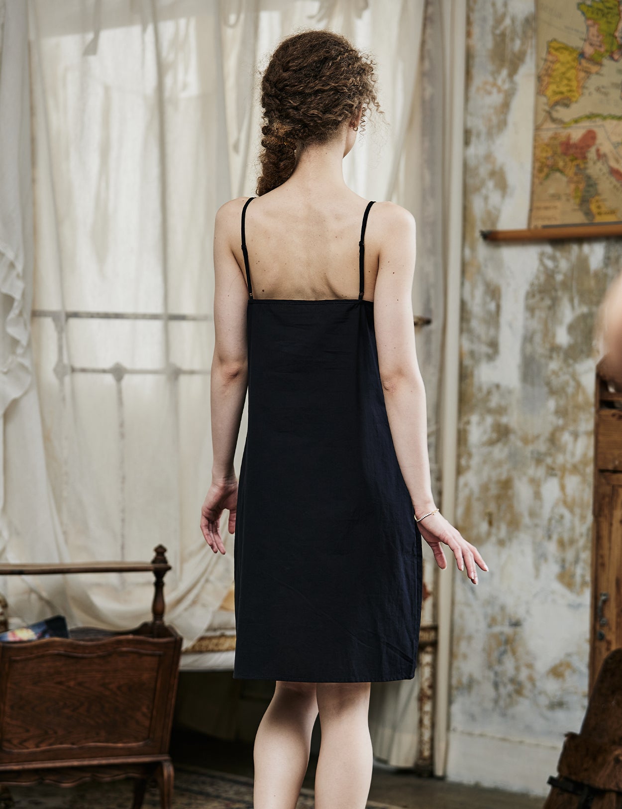 Women's black cotton full slip with spaghetti straps, showing comfortable fit and classic design - back view